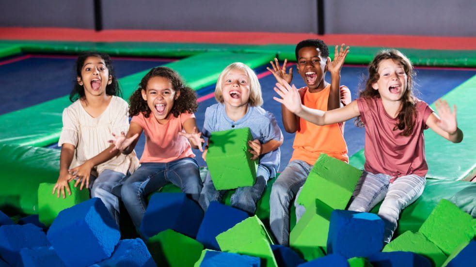 Five children sat in a trampoline park